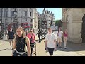 NEW SIGNS DON'T TOUCH THE HORSE are hung and STRAIGHTENED by a tourist at Horse Guards!