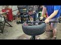 Harbor Freight Pittsburgh black manual tire changer mounting low profile tire using duck head.