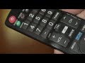 woman turning the volume up on a television remote control